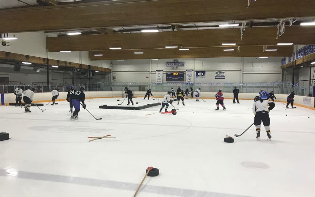 Adult hockey players performing drills