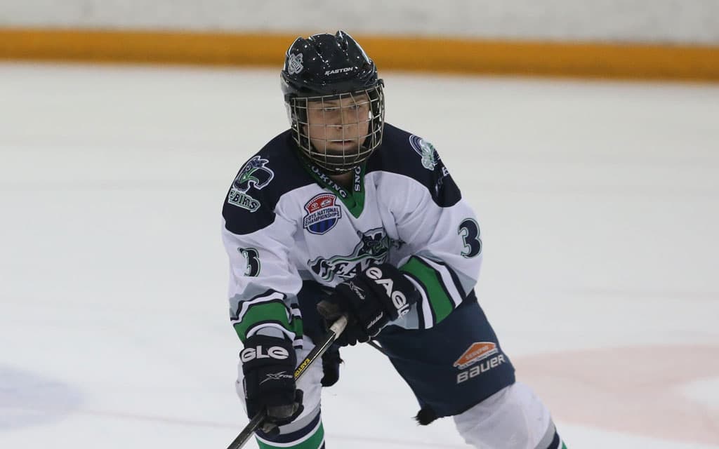 Youth hockey player focuses on puck